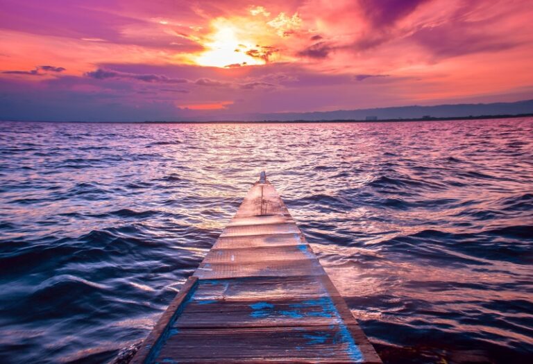 lindo-nariz-pequeno-barco-vela-mar-com-incríveis nuvens-vermelho-céu